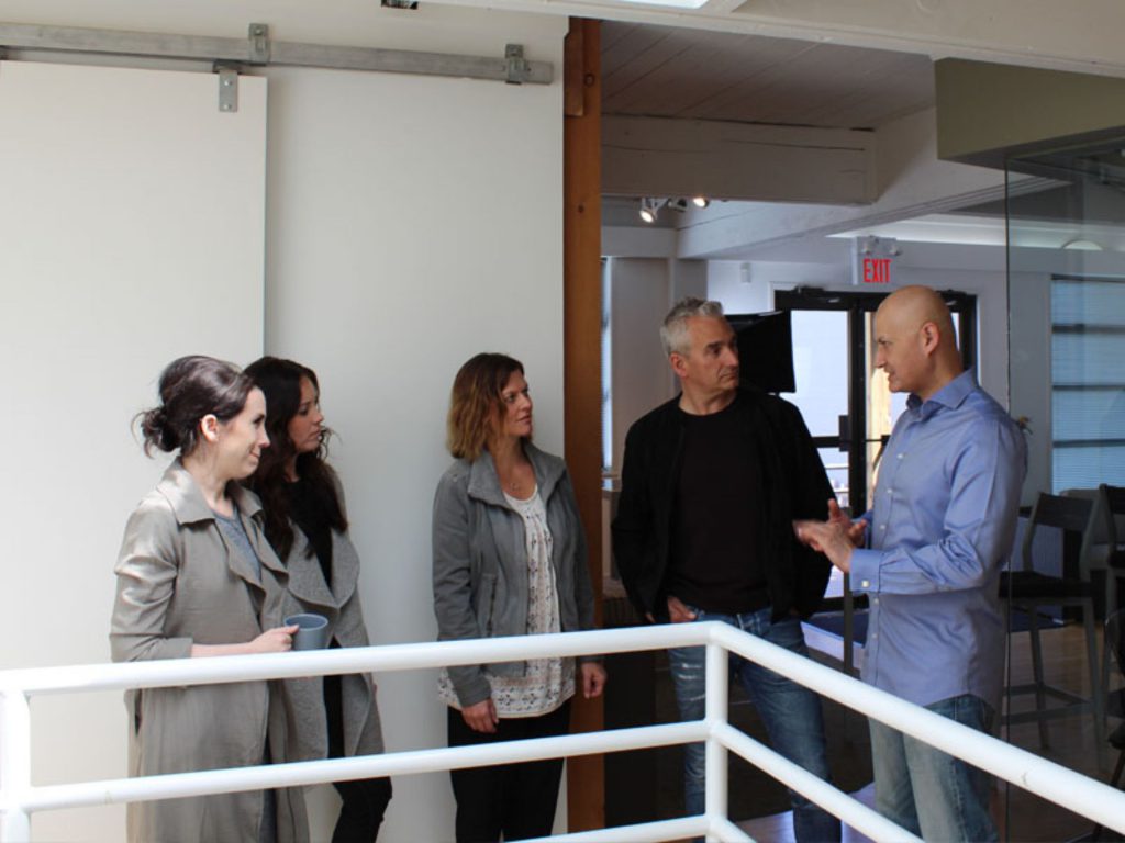 Group of colleagues engaging in a lively discussion in a modern office setting.